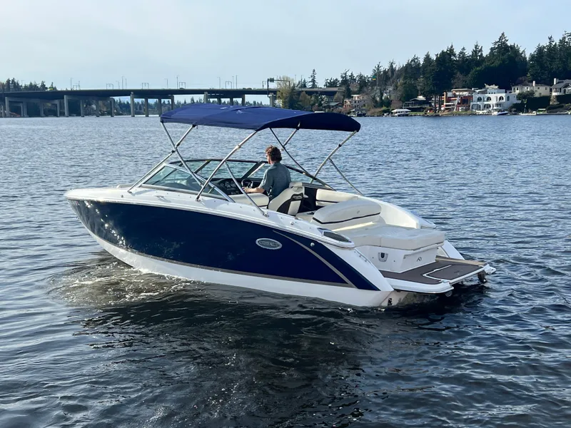 Slide: The Image of 2015 Cobalt R3 boat cruising on a scenic lake with a bridge in the background. - 10