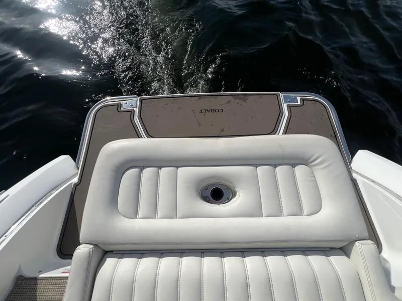 Slide: The Image of Rear view of a 2015 Cobalt R3 boat with cushioned seating and water backdrop. - 11