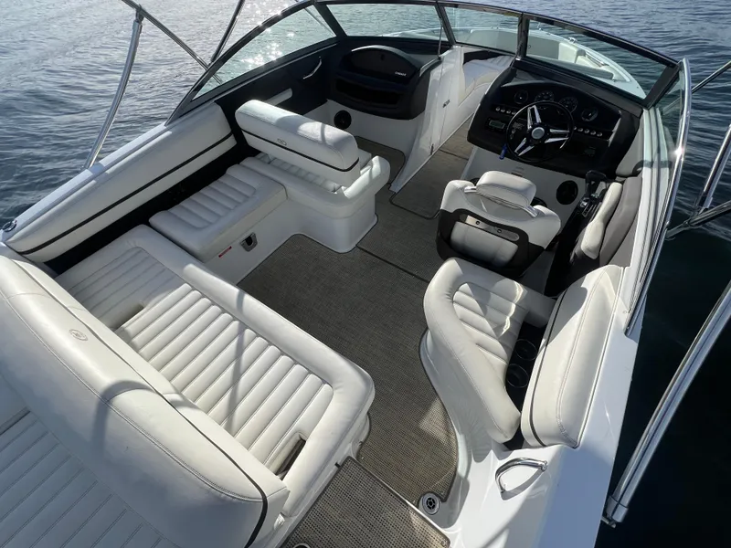 Slide: The Image of 2015 Cobalt R3 boat interior with white leather seating and modern dashboard on water. - 13