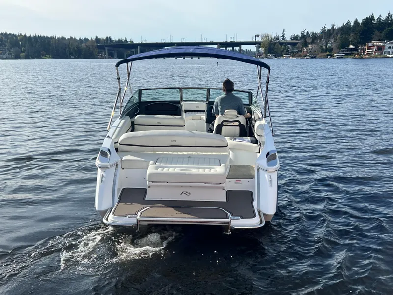 Slide: The Image of 2015 Cobalt R3 boat cruising on a scenic lake with a bridge in the background. - 8