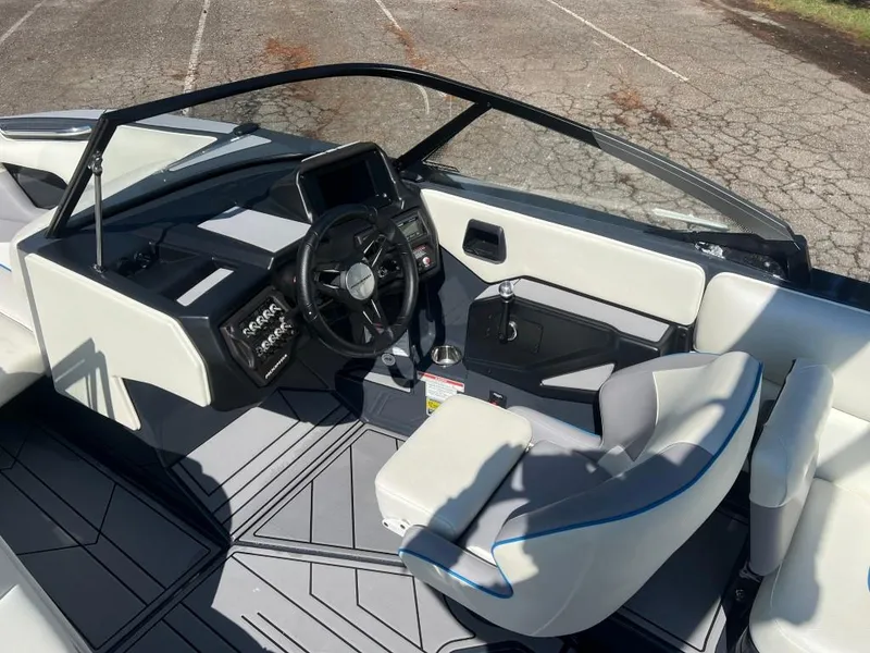 Slide: The Image of 2022 Moomba Mojo boat interior with modern dashboard and comfortable seating. - 12