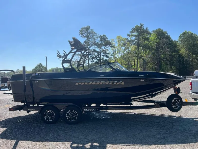 Slide: The Image of 2022 Moomba Mojo boat on trailer, parked outdoors under clear blue sky. - 4