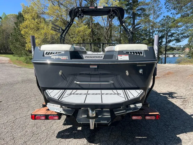 Slide: The Image of 2022 Moomba Mojo boat rear view, parked on a lakeside road with trees in the background. - 6