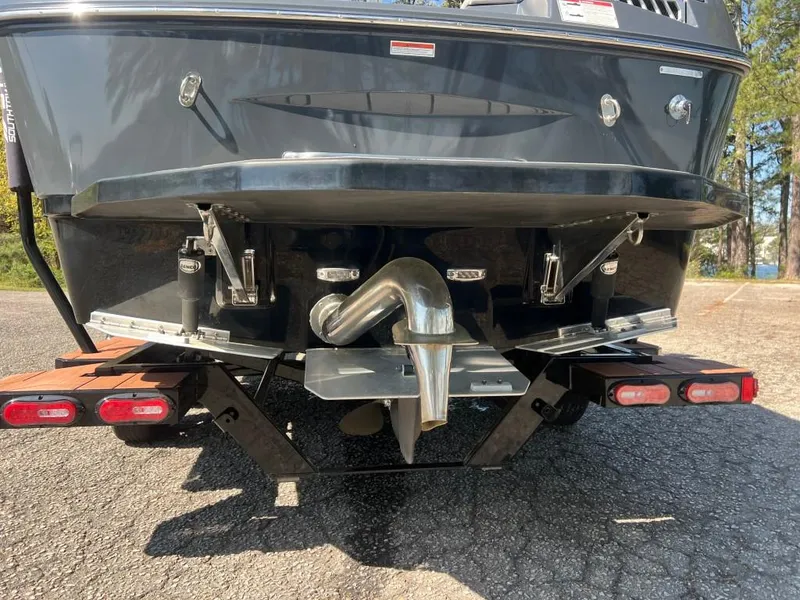 Slide: The Image of Rear view of a 2022 Moomba Mojo boat on a trailer, showcasing exhaust and trim tabs. - 7