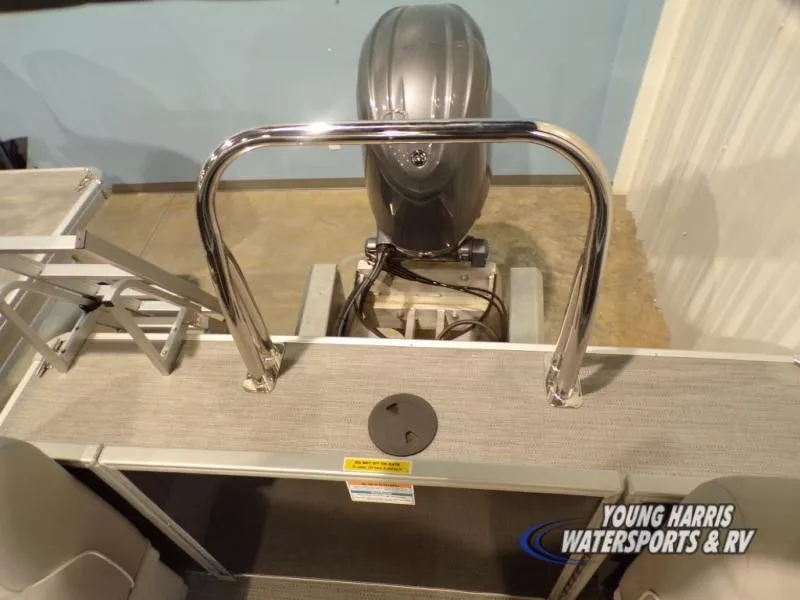 Slide: The Image of 2025 Godfrey EX2286SB boat with motor and railing, displayed indoors. - 8