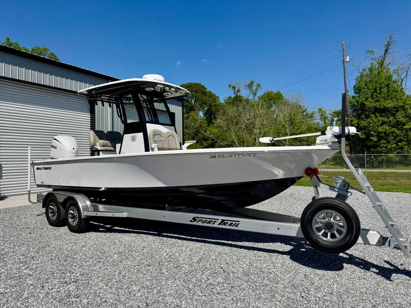 Slide: The Image of 2022 Sportsman 247OE boat on trailer, parked outdoors near a metal building. - 1