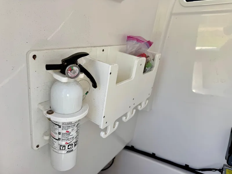 Slide: The Image of Fire extinguisher and storage compartments on a 2022 Sportsman 247OE boat. - 12