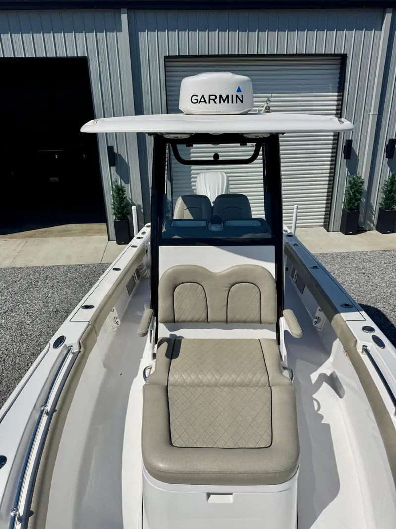 Slide: The Image of 2022 Sportsman 247OE boat with Garmin equipment, parked near a garage. - 7