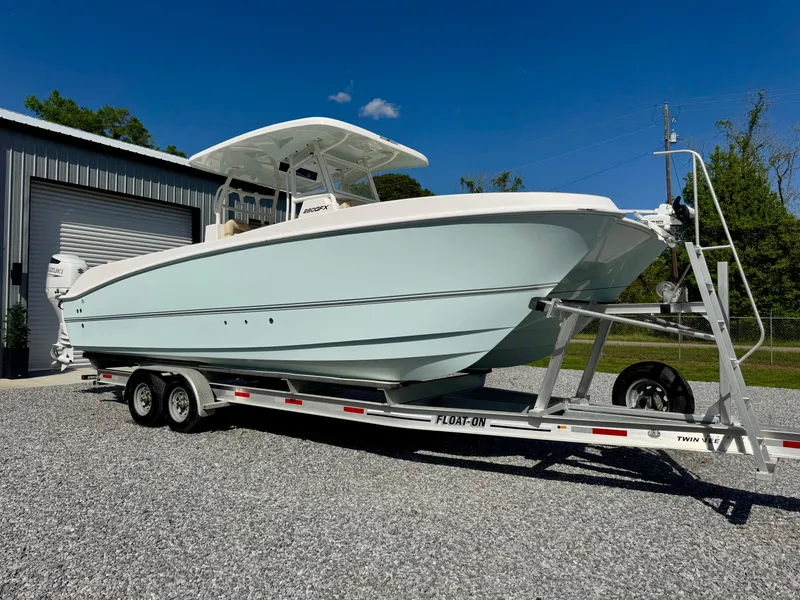 Slide: The Image of 2023 Twin Vee 280 GFX CC boat on trailer, parked outdoors under clear blue sky. - 16