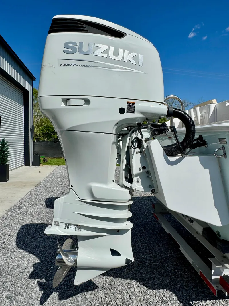 Slide: The Image of 2023 Twin Vee 280 GFX CC with Suzuki outboard motor, parked on gravel. - 19