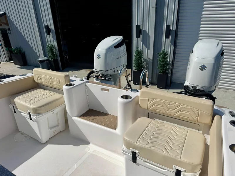 Slide: The Image of 2023 Twin Vee 280 GFX CC boat interior with dual outboard motors and cushioned seating. - 23