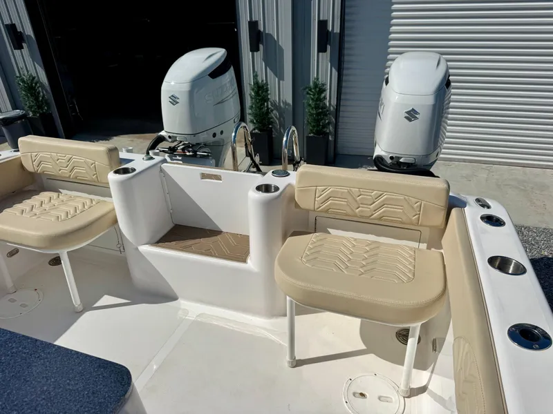 Slide: The Image of 2023 Twin Vee 280 GFX CC boat interior with beige seating and dual outboard engines. - 25