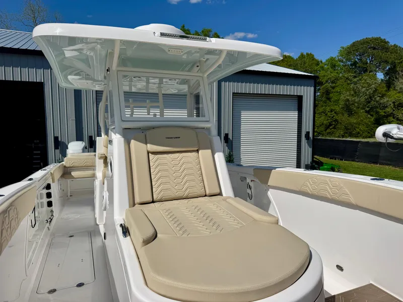 Slide: The Image of 2023 Twin Vee 280 GFX CC boat with beige seating, docked near metal buildings. - 39