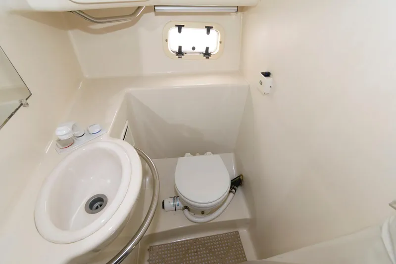 Slide: The Image of 1996 Maxum 2700 SCR boat bathroom with sink, toilet, and porthole window. - 12