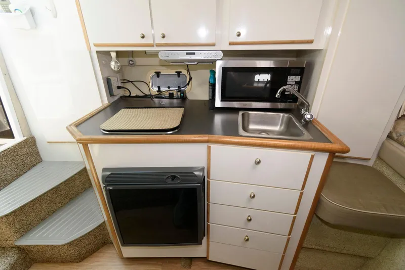 Slide: The Image of Compact kitchen area in a 1996 Maxum 2700 SCR boat with microwave and sink. - 7