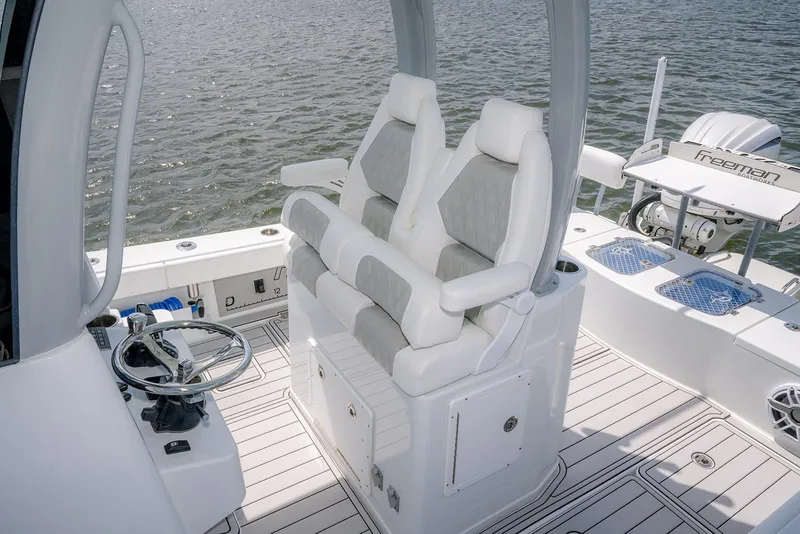 Slide: The Image of 2024 Freeman 28 boat interior with dual seats and steering wheel on water. - 11