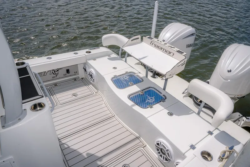 Slide: The Image of 2024 Freeman 28 boat deck with Yamaha engines, featuring fishing amenities and ocean backdrop. - 12