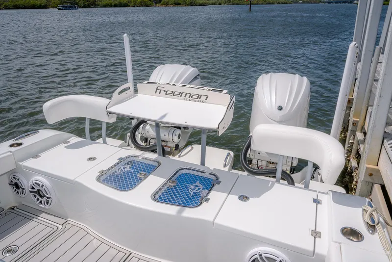 Slide: The Image of 2024 Freeman 28 boat with dual engines and fishing setup on calm water. - 14