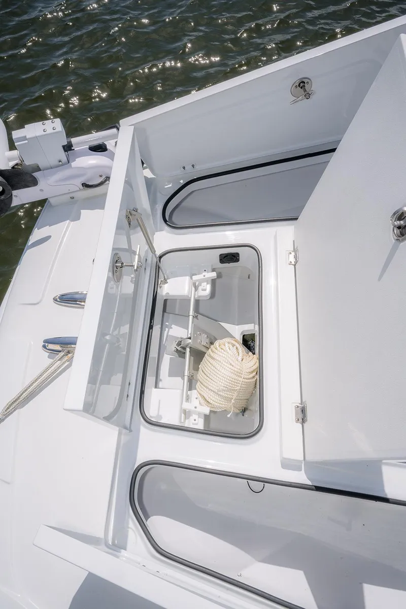 Slide: The Image of 2024 Freeman 28 boat storage compartment with rope, open on calm water. - 17