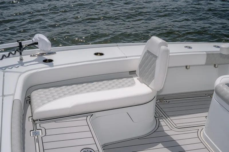 Slide: The Image of 2024 Freeman 28 boat with white cushioned seating on deck, near water. - 26