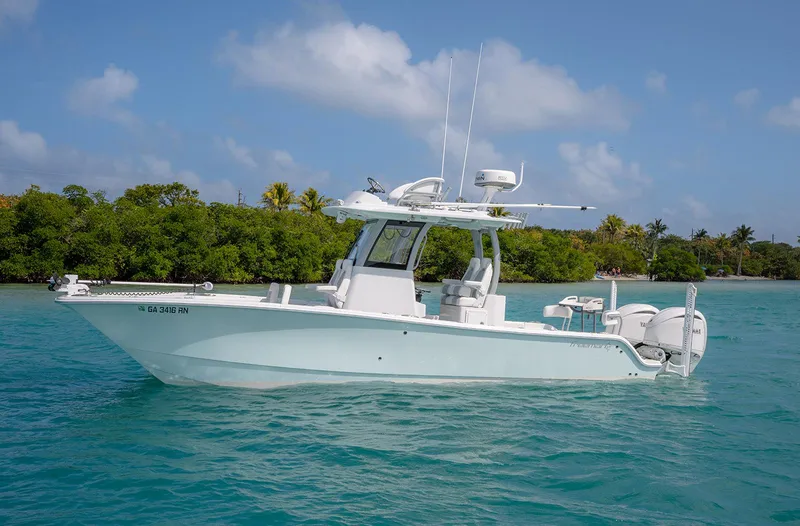 Slide: The Image of 2024 Freeman 28 boat on turquoise water with lush green background. - 29