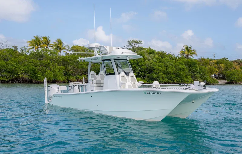 Slide: The Image of 2024 Freeman 28 boat on water, surrounded by lush greenery and clear blue sky. - 30