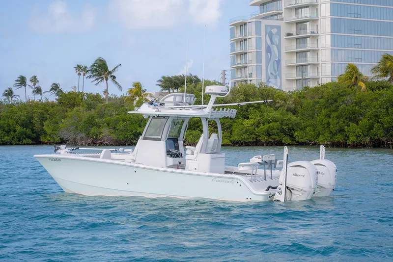 Slide: The Image of 2024 Freeman 28 boat on water near tropical shoreline and modern building. - 31