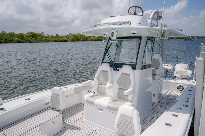 Slide: The Image of 2024 Freeman 28 boat with sleek design, spacious deck, and modern seating on a calm river. - 5