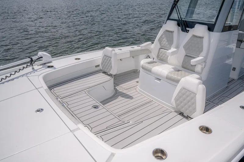 Slide: The Image of 2024 Freeman 28 boat interior with cushioned seating and sleek deck design on the water. - 6