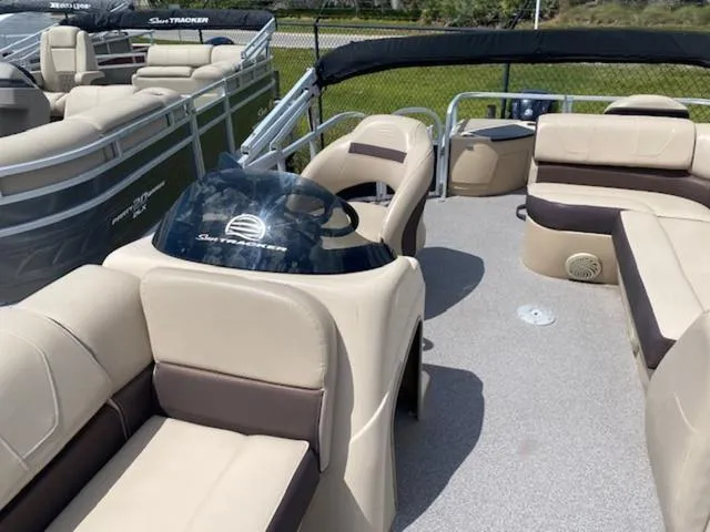 Slide: The Image of 2018 Sun Tracker FISHIN' BARGE® 20 DLX pontoon boat with beige seating and helm. - 3