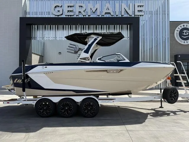 Slide: The Image of 2025 Tigé 23ZX boat on a trailer at Germaine dealership, showcasing sleek design and modern features. - 1