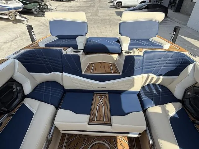 Slide: The Image of 2025 Tigé 23ZX boat interior with blue and white seating, wood accents, and cup holders. - 11