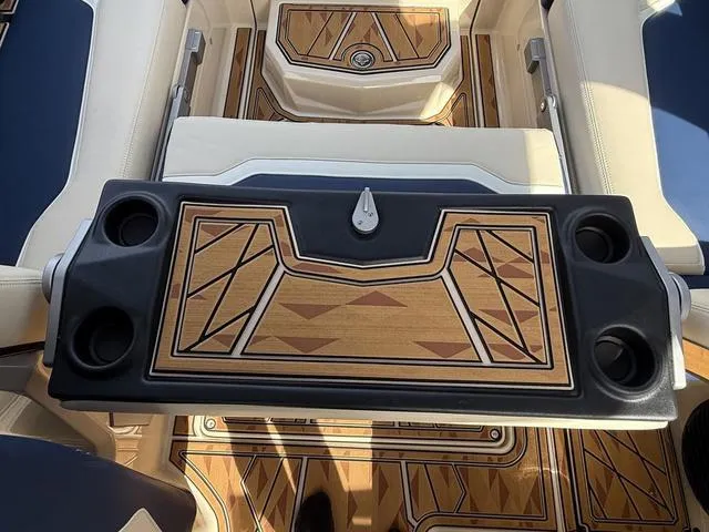 Slide: The Image of 2025 Tigé 23ZX boat interior with stylish wood-patterned table and cup holders. - 17
