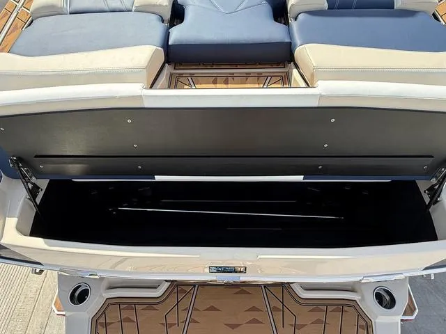 Slide: The Image of 2025 Tigé 23ZX boat with open storage compartment and cushioned seating. - 18