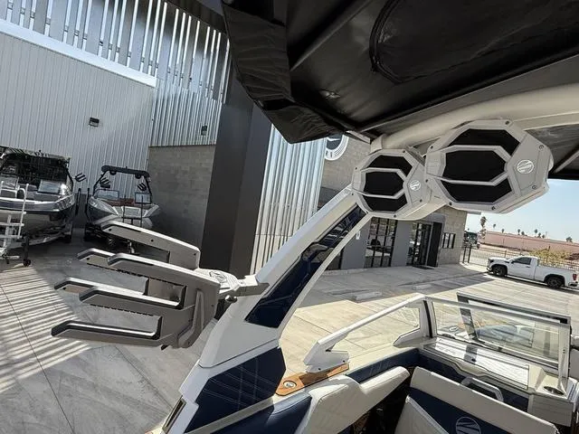 Slide: The Image of 2025 Tigé 23ZX boat with advanced audio system and sleek design in a modern marina setting. - 19