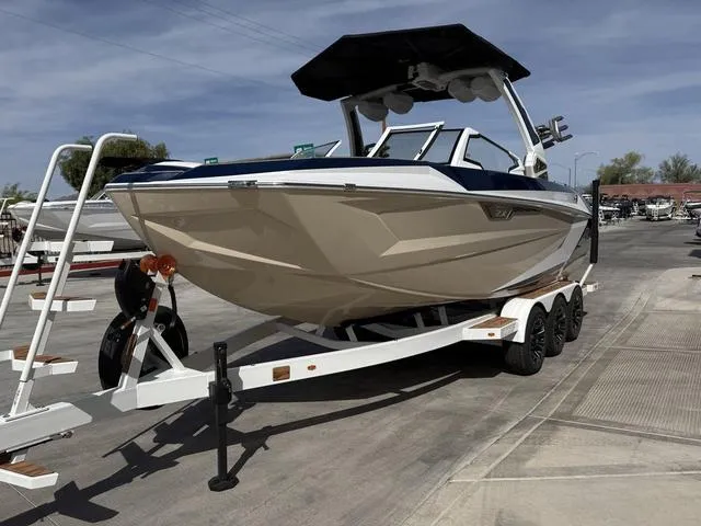 Slide: The Image of 2025 Tigé 23ZX boat on trailer, sleek design, parked outdoors under clear sky. - 4