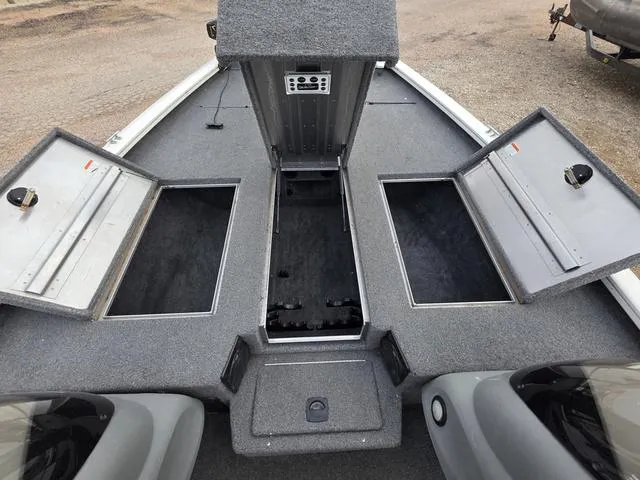 Slide: The Image of 2017 Tracker 195 boat interior with open storage compartments and gray carpeting. - 10