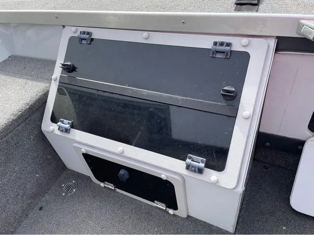 Slide: The Image of 1998 Alumacraft PRO 195 boat storage compartment with black latch cover. - 17