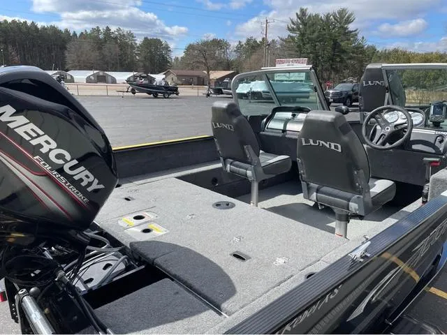 Slide: The Image of 2016 Lund 1650 Rebel XL Sport boat with Mercury engine, featuring spacious interior and dual seats. - 10