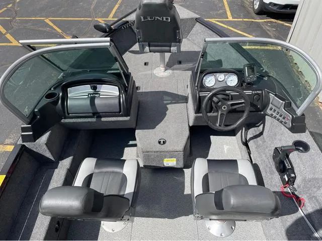 Slide: The Image of 2016 Lund 1650 Rebel XL Sport boat interior with steering console and seating. - 11
