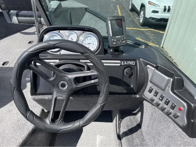 Slide: The Image of 2016 Lund 1650 Rebel XL Sport boat dashboard with steering wheel and gauges. - 12