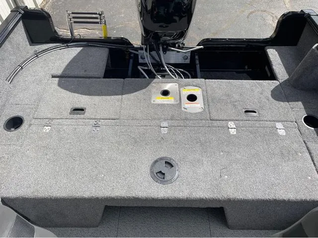 Slide: The Image of 2016 Lund 1650 Rebel XL Sport boat interior with motor and storage compartments. - 16