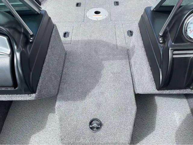 Slide: The Image of 2016 Lund 1650 Rebel XL Sport boat interior with gray carpet and dashboard details. - 20
