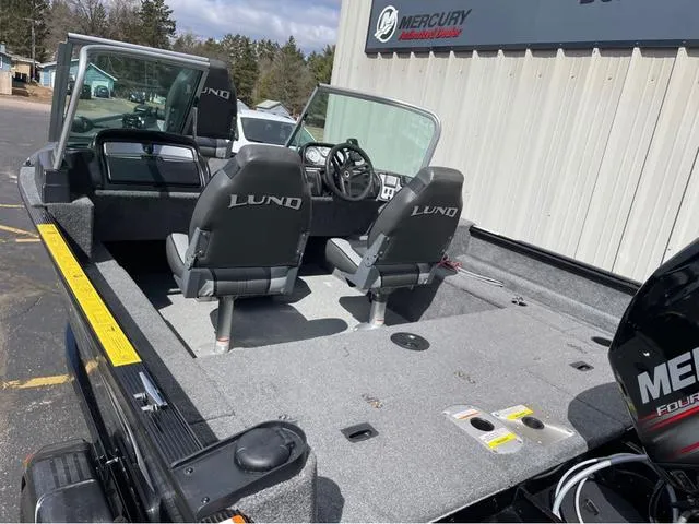 Slide: The Image of 2016 Lund 1650 Rebel XL Sport boat interior with two seats and Mercury engine. - 7