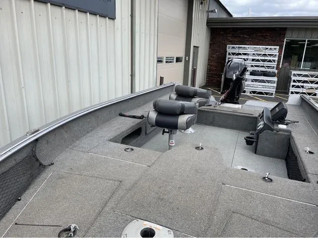 Slide: The Image of 2017 Lund 1675 Pro Guide fishing boat with seating and motor, parked near a building. - 30