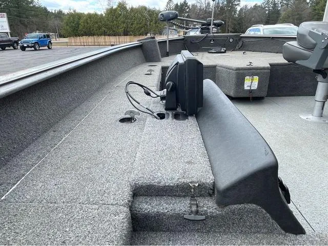 Slide: The Image of 2017 Lund 1675 Pro Guide boat interior with seating and equipment, parked outdoors. - 37