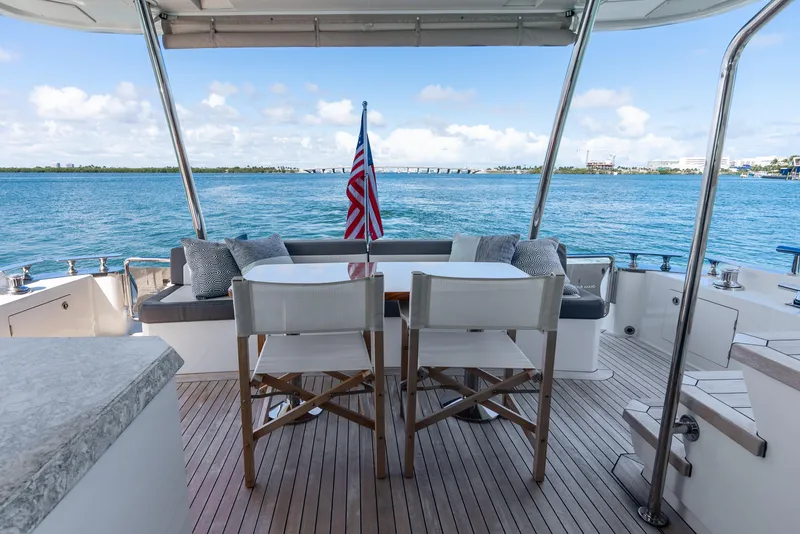 Slide: The Image of Ocean Alexander 70E Motoryacht 2021 aft deck with seating, table, and ocean view. - 16