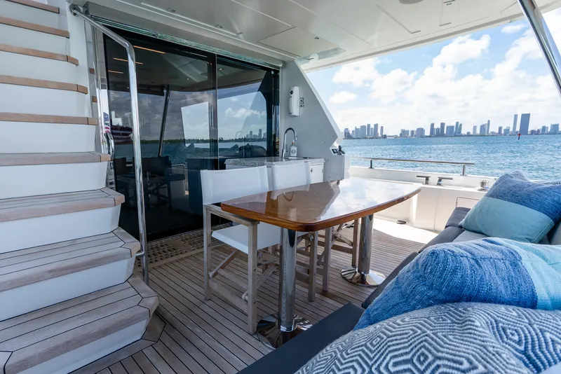 Slide: The Image of Ocean Alexander 70E Motoryacht 2021 deck with dining area, city skyline view. - 17