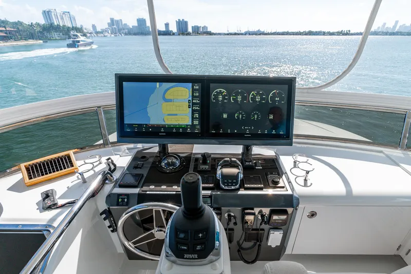 Slide: The Image of 2021 Ocean Alexander 70E Motoryacht helm with navigation screens, steering wheel, and ocean view. - 27