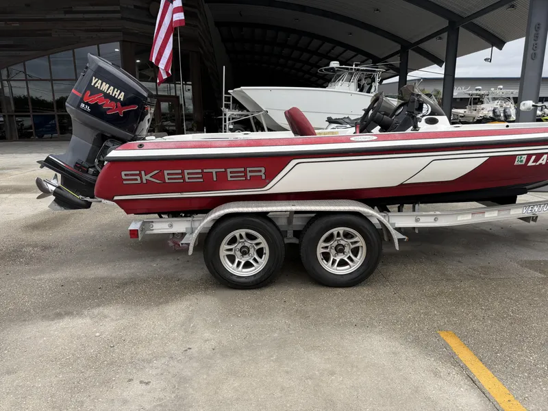Slide: The Image of 2005 Skeeter SX 200 boat on trailer with Yamaha VMAX engine, parked outdoors. - 1